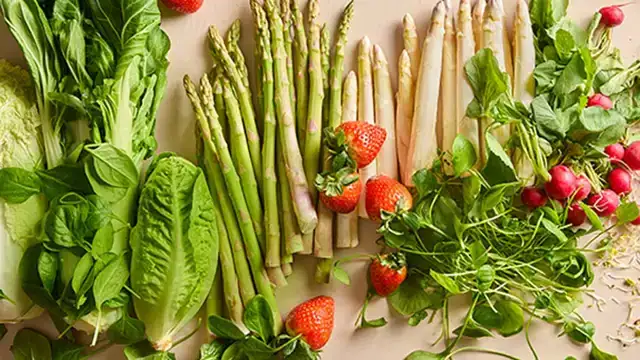 Een foto van allerlei seizoensgroenten van de lente: chinese kool, asperges, aardbeien, radijsjes en kiemen